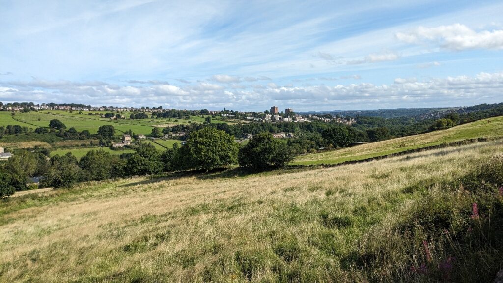View of fields and wider landscape, city outskirts, horizon with blue sky